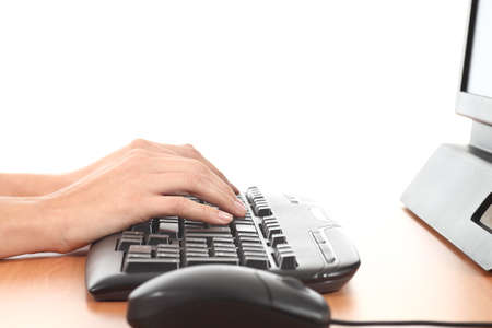 Woman hands on a black computer keyboard with a white isolated backgroundの写真素材