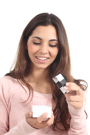 Teen girl smiling opening a gift box in a white isolated background                の写真素材