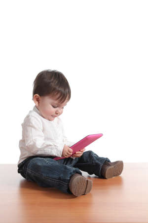 Baby concentrated in a tablet pc with a white isolated background の写真素材