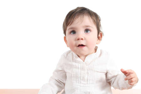 Baby puzzled watching up with a big blue eyes on a white isolated background   の写真素材