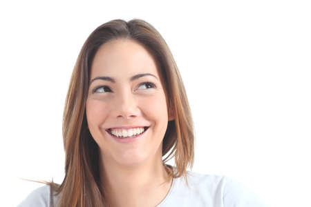 Woman smiling with her eyes looking at side on a white isolated backgroundの写真素材