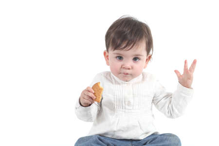 Baby eating a cookie on a white isolated background               の写真素材