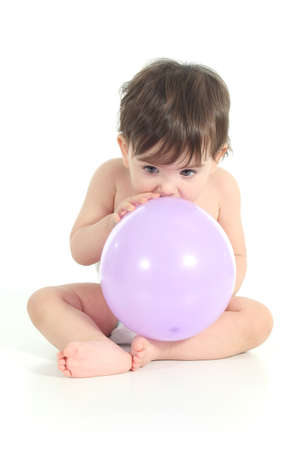 Baby trying to inflate a balloon on a white isolated background              の写真素材