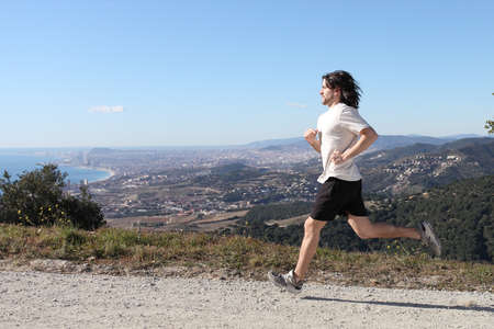 Man running in the mountain with whole Barcelona city in the backgroundの写真素材