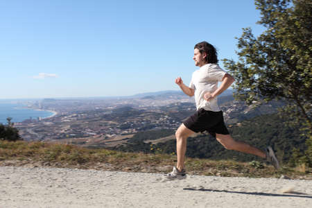 Man running on a path with Barcelona city in the backgroundの写真素材