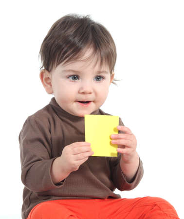 Baby holding and showing a blank yellow note on a white isolated background               の写真素材