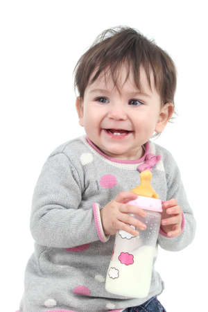 Happiness baby holding a feeding bottle on a white isolated backgroundの写真素材