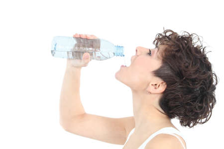Woman drinking water from a plastic bottle on a white isolated background              の写真素材
