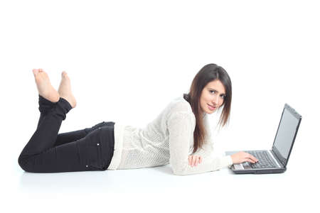 Beautiful woman lying with a laptop on a white isolated background              の写真素材