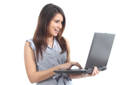 Beautiful woman standing amazed watching a laptop on a white isolated backgroundの写真素材