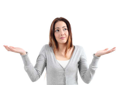 Beautiful woman with a doubt shrugging her shoulders on a white isolated backgroundの写真素材