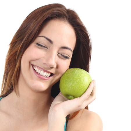 Beautiful woman holding a green apple close to her face on a white isolated backgroundの写真素材