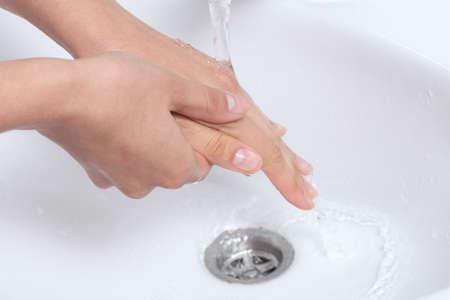 Woman rubbing and washing her hands under a waterjet              