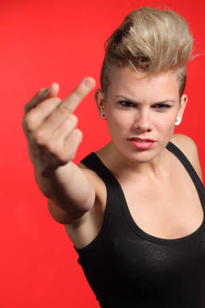 Fashion teenager girl showing middle finger isolated on a white backgroundの写真素材