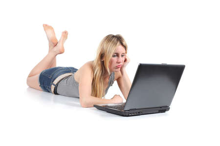 Beautiful woman bored with her old laptop isolated on a white backgroundの写真素材