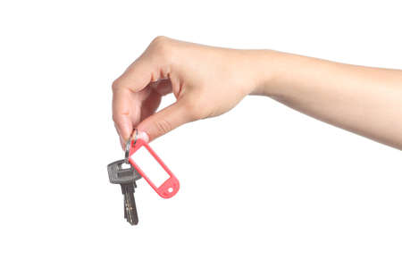 Side view of a woman hand giving a house keys isolated on a white backgroundの写真素材