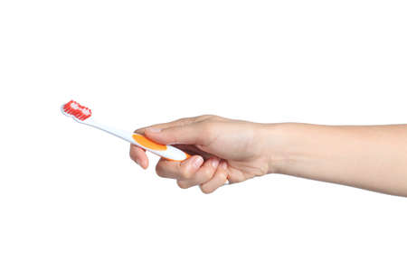 Woman hand holding a toothbrush isolated on a white background              の写真素材