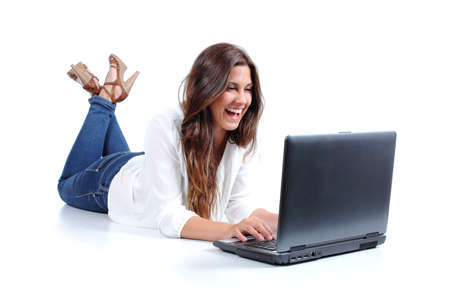 Attractive woman lying happy browsing in her laptop isolated on a white background        の写真素材