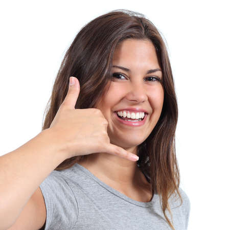 Attractive teenager girl making call me gesture with her hand isolated on a white backgroundの写真素材