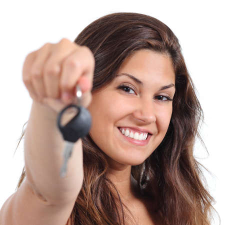 Beautiful woman smiling and holding her car key isolated on a white backgroundの写真素材
