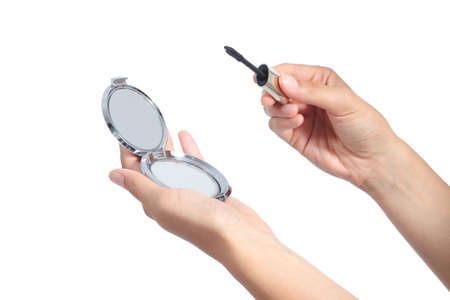 Woman hands holding a hand mirror and a lash mascara ready to make up isolated on a white backgroundの写真素材