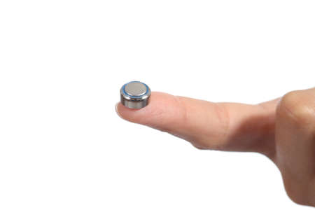 Woman hand holding a button battery with the forefinger isolated on a white background            の写真素材