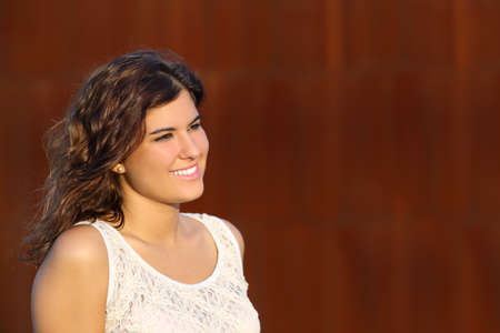 Portrait of a beautiful woman smiling with a corten steel backgroundの写真素材