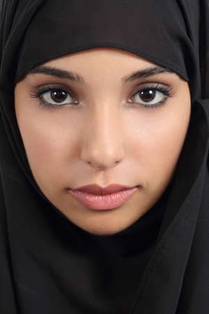 Portrait of a front view of a beautiful arab woman face with a black scarf     の写真素材