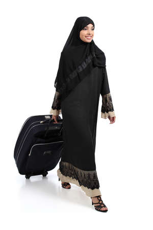 Arab woman walking carrying a suitcase isolated on a white background             の写真素材