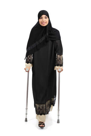Arab woman walking with crutches isolated on a white background               の写真素材