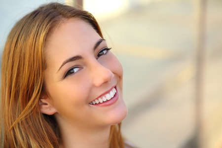 Beautiful woman with a perfect white smile and smooth skin with an unfocused background              の写真素材
