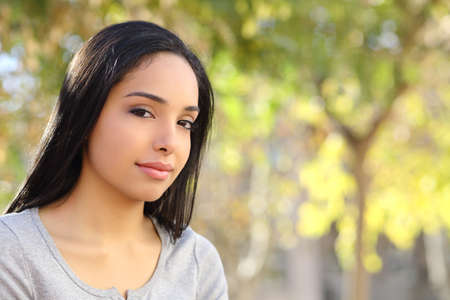 Portrait of a beautiful woman in a park with a green unfocused background             の写真素材