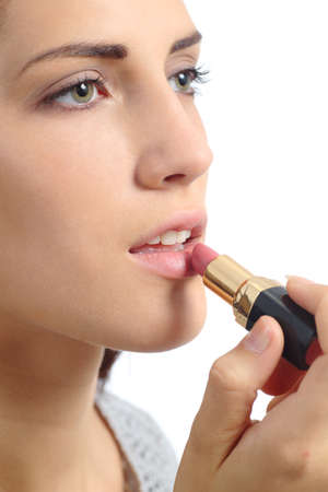 Close up of a beautiful woman applying a lipstick on lips isolated on a white backgroundの写真素材