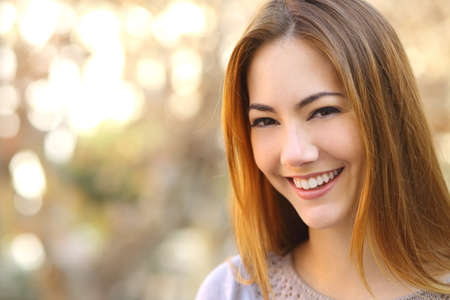Portrait of a beautiful happy woman with a perfect white smile with a warmth background           の写真素材