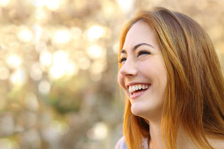 Facial portrait of a funny woman face laughing with a warmth background        の写真素材
