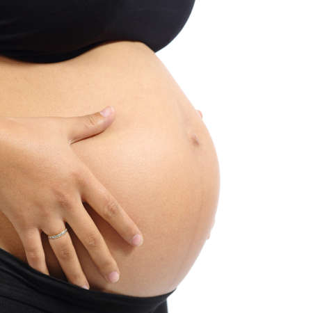 Close up of a pregnant woman tummy isolated on a white backgroundの写真素材