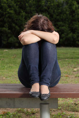 Front view of a teenager lonely depressed and sadness in a parkの写真素材