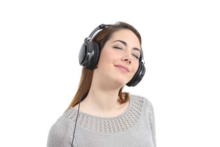 Woman listening to the music with headphones and eyes closed isolated on a white backgroundの写真素材