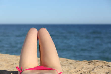Woman legs sunbathing on the beach with the horizon in the background      の写真素材
