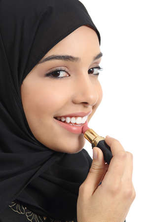 Portrait of an arab saudi emirates woman painting her lips with a lipstick isolated on a white background             の写真素材
