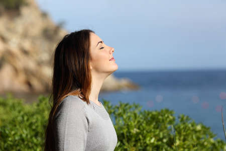 Woman breathing fresh air relaxed on vacation with the beach in the background      の写真素材