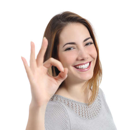 Close up of a happy woman with perfect smile gesturing ok isolated の写真素材