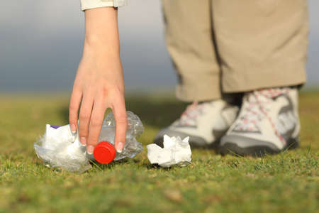 Eco hiker hand collecting garbage in the grass of the mountainの写真素材