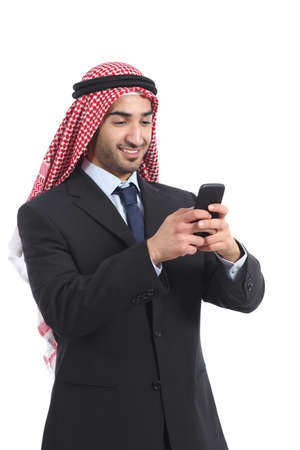 Arab saudi executive smiling and using a smart phone isolated on a white background               の写真素材