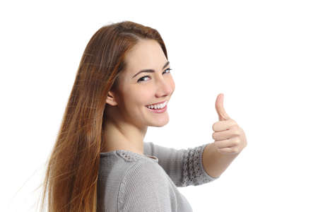 Back view of a happy woman making thumb up gesture isolated on a white backgroundの写真素材