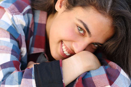 Very close up portrait of a happy beautiful teenager girl smiling and looking at camera           の写真素材