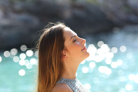 Girl breathing fresh air on a tropical beach on holidays with the sea in the backgroundの写真素材