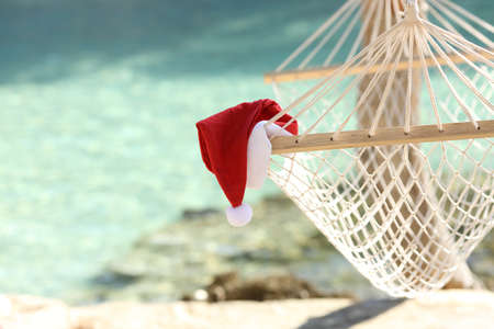 Santa claus hat on Hammock in a tropical beach resort with the sea water in the backgroundの写真素材