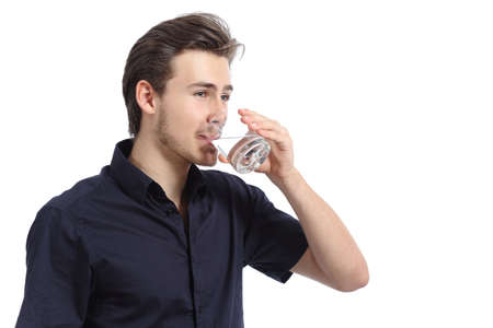 Attractive happy man drinking water from a glass isolated on a white background