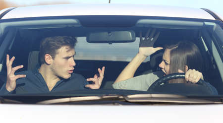 Couple arguing while she is driving a car in a dangerous situationの写真素材